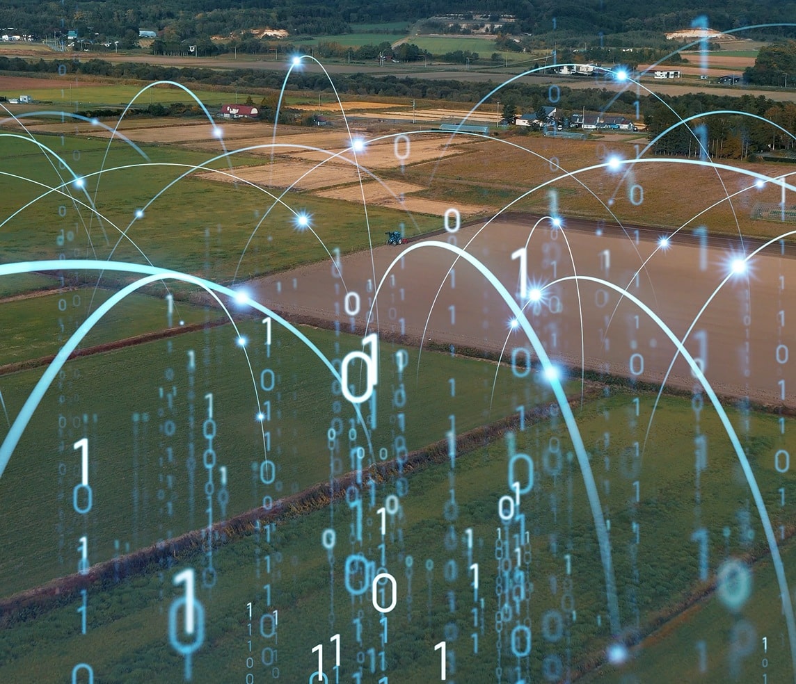 Aerial view of farmland overlaid with digital data streams and binary code, symbolizing agricultural technology and smart farming.